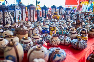 Variety of traditional asian ceramic opium pipes on on the counter at Donsao Market, Laos. clipart