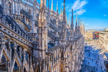 Milan Katedrali 'nin çatısı, kulelerden oluşan bir ormanla, özenle oyulmuş taş heykellerle ve ayrıntılı olarak döşenmiş duvarlarla süslenmiştir. Milan, İtalya.