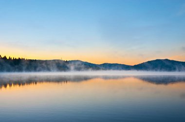 Mladost Gölü, Veles, Kuzey Makedonya 'nın buharlı sularının üzerinde berrak gün doğumu gökyüzü