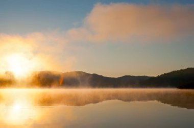 Mladost Gölü 'nden yükselen buhar, güneşin doğuşu ışığında altın gibi parlıyor, Veles, Kuzey Makedonya