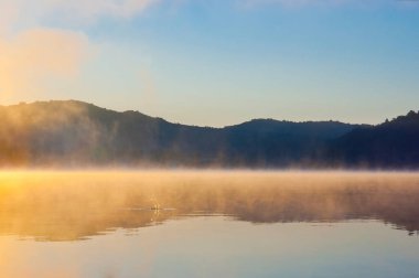 Sessiz, buharlı Mladost Gölü, Kuzey Makedonya 'nın Veles kentindeki atlayan bir balığın düşüşünden rahatsız oldu.