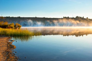 Veles 'teki Mladost Gölü boyunca sabah yürüyüşü, yükselen buhar manzarasıyla, Kuzey Makedonya' da altın gündoğumuyla aydınlandı.