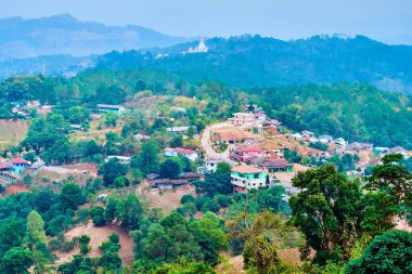 The foggy mountain scenery of agricultural region of Chiang Rai suburb with emerald tea plantations of Mae Salong Chinese Yunnan tea village, Thailand clipart