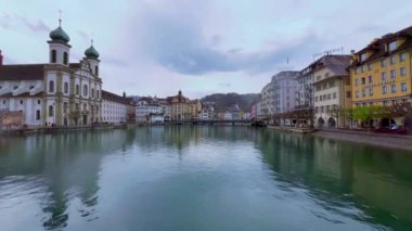 Yağmurlu bir günde Lucerne şehrinin manzarası Reuss, Cizvit Kilisesi ve tarihi konak evleri, freskleri, renkli ahşap panjurları ve fayanslı çatıları, İsviçre