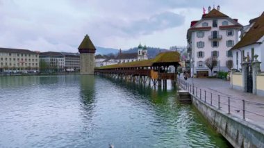 Lucerne 'nin yağmurlu şehir merkezi, Wasserturm su kulesi, Reuss Nehri ve Rathausquai rıhtımı, İsviçre' deki ortaçağ ahşap kapellbrucke köprüsü manzaralı.