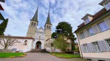 St. Leodegar Kilisesi 'nin panoraması, tarihi binalar, yarı keresteli evler, yeşil çimenler, çiçek açan manolyalar ve diğer ağaçlar, St Leodegarstrasse Caddesi, Lucerne, İsviçre