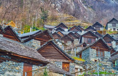 The dense stone-timber houses on the steep mountain slope in Brontallo, Val Lavizzara, Vallemaggia, Ticino, Switzerland clipart