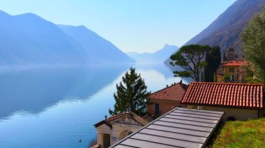 Lugano Gölü 'nün kıyısındaki Oria' nın çatılarında arka planda Lugano Prealps, Valsolda, İtalya