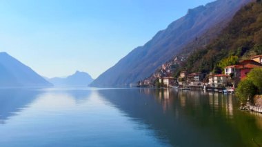 Monte San Salvatore 'un puslu silueti ile dağ manzarası aynaya benzeyen Lugano Gölü' nün arkasında San Mamete, Valsolda, İtalya seti.