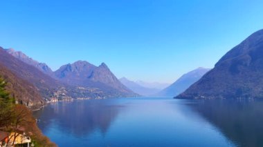 İsviçre köyü Gandria, İtalya 'nın Lombardiya eyaletinde yer alan Monte dei Pizzone ve Monte Bronzone ile Lugano Gölü ve Alp manzarasını gözlemler.
