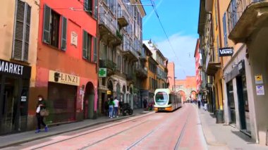 Renkli evleri olan Corso di Porta Ticinese 'deki klasik sarı tramvay ve Porta Ticinese Ortaçağ Kapısı (Milano), Milano, İtalya