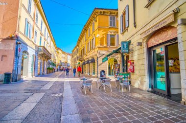 MONZA, ITALY - APRIL 11, 2022: Via Italia one of the central pedestrian streets in medieval Monza town, on April 11 in Monza, Italy