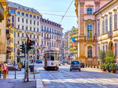 MILAN, ITALY - APRIL 11, 2022: Retro styled tram rides along Corso Magenta street in central neighborhood, on April 11 in Milan, Italy