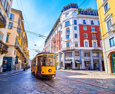 MILAN, ITALY - APRIL 11, 2022: Yellow retro tram rides along Corso Magenta street, on April 11 in Milan, Italy clipart