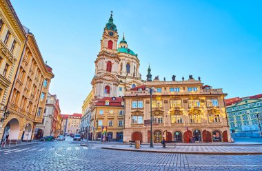 PRAG, CZECHIA - 20 Mart 2022 'de Malostranske Meydanı, Mala Strana, Prag, Çek Cumhuriyeti' ndeki klasik evlerin arkasında görülen seçkin Aziz Nicholas Kilisesi