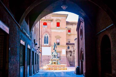 Neptune Çeşmesi 'nin manzarası Palazzo Re Enzo, Bologna, İtalya' daki kemerli geçitten geçti.