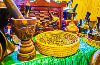 DUBAI, UAE - MARCH 2, 2020: The cookware for Ethiopian coffee ceremony: woven bowl with raw coffee beans, mortar and pestle, different jebena pots for coffee boiling, on March 2 in Dubai, UAE clipart