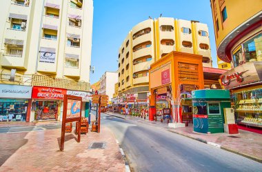 DUBAI, BAE - 2 Mart 2020: Deira Grand Souq 'un (pazar) çeyreklikleri boyunca uzanan Eski Baladiya caddesinde yürüyün; Altın Çorba' nın ahşap kapısı 2 Mart 'ta Dubai' de modern binalar arasında görülmektedir.