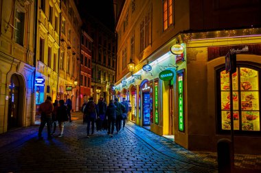 PRAGUE, CZECH REPUBLIC - 4 Mart 2022: Çok sayıda bar, kafe ve restoran, Çek Cumhuriyeti 'nin Prag kentinde, eski kentin en kalabalık şehri olan Karlova Caddesi boyunca yürüyen misafirleri davet ediyor.