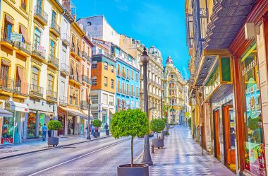 GRANADA, SPAIN - SEPTEMBER 25, 2019: The vibrant life in busy shopping Calle Reyes Catolicos street with luxury edifices, fast traffic, many fashion stores and cafes, on September 25 in Granada
