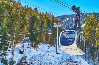 Zell See, Avusturya - 28 Şubat 2019: Hızlı gondol telesiyeji ve modern Porsche tasarım telesiyeji, 28 Şubat'ta Zell See'de Schmittenhohe dağının tepesinden sporcuları ve turistleri taşıyor