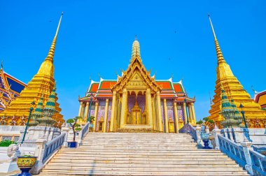 BANGKOK, THAILAND - 12 Mayıs 2019: Turistler 12 Mayıs 'ta Tayland' ın Bangkok kentindeki Grand Palace kompleksinin avlusunda tarihi tapınaklar arasında yürüyorlar