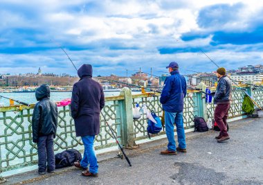 Galata Köprüsü 'ndeki balıkçılar, İstanbul' un hareketli şehir manzarasının ikonik bir bölümü, Türkiye