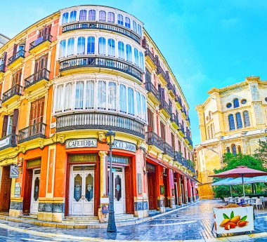 Malaga, İspanya - 26 Eylül 2019: Köşeli cepheli klasik Akdeniz binası, Cister Caddesi zemin katındaki büyük balkonlar ve kafe, 26 Eylül 'de Malaga' da