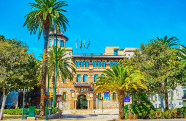 Malaga, İspanya - 26 Eylül 2019: Malaga Üniversitesi ön planda gür palmiye ağaçları bulunan cephesi, 26 Eylül 'de Malaga' da