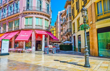 Malaga, İspanya - 26 Eylül 2019: Calle Larios alışveriş caddesindeki açık hava restoranı, renkli güneş gözlüğü ve küçük masalar, 26 Eylül 'de Malaga' da
