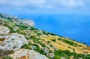 Dingli Cliffs ve Malta Akdeniz, Guastalla, Kuzey Bölgesi sakinleştirmek yüzey üzerinde alçak yağmurlu bulutlar.