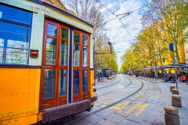 Ağaç kaplı Corso Sempione Bulvarı 'ndaki klasik tramvay turları. Güzel açık hava restoranları ve tepecikleri, Milan, İtalya.