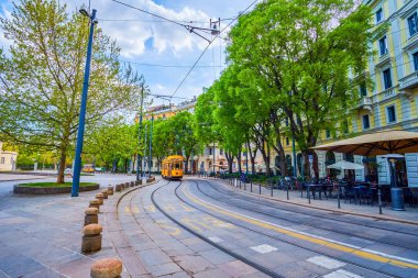 Piazza Sempione 'de klasik tramvay, Milano, İtalya' da güzel açık hava terasları ve yerel restoran ve meyhanelerin önünden geçiyor.