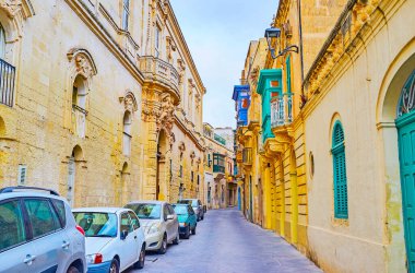 Şehrin dar sokağında, Rabat, Malta 'da oyulmuş çelenkler, desenler ve heykellerle süslenmiş görkemli köşkler ve tarihi binalar var.