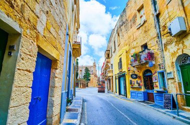 RABAT, MALTA - 16 Haziran 2018: St. Paul caddesi kafeleri, hediyelik eşya dükkanları ve St. Paul Kilisesi arka planda, 16 Haziran 'da Malta' nın Rabat kentinde