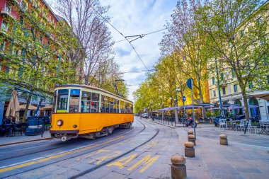 Ağaç kaplı Corso Sempione Bulvarı 'ndaki klasik tramvay turları. Güzel açık hava restoranları ve tepecikleri, Milan, İtalya.
