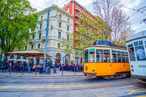 MILAN, ITALY - 8 Nisan 2022: 8 Nisan 'da İtalya' nın Milano kentinde, Piazza Sempione 'deki klasik tramvay turları yerel restoranların sevimli açık hava teraslarından geçiyor.