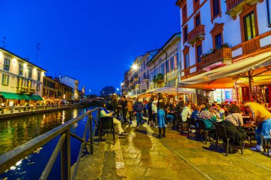MILAN, ITALY - 08 Nisan 2022: Naviglios kanalının gece cazibesi müzik ve gece geç saatlerde konuşmalarla birlikte, 8 Nisan 'da İtalya' nın Milano kentinde