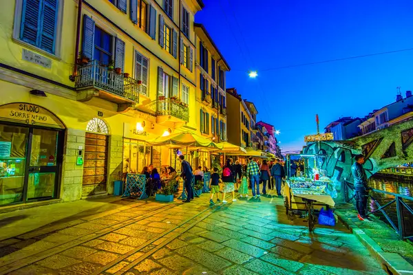 MILAN, ITALY - 08 Nisan 2022: Tarihsel cazibe, 8 Nisan 'da İtalya' nın Milano kentinde hava karardıktan sonra Naviglio Grande 'de modern uğultuyla buluşur