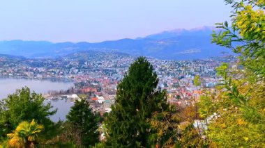 Monte Bre yamacındaki çiçek açan baharın arka planında Lugano Gölü 'nün mor yansıması ve arka planda puslu Monte San Salvatore, Lugano, Ticino, İsviçre