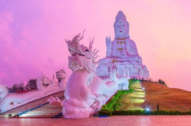 İkonik beyaz Guan Yin heykeli Wat Huai Pla Kang, Chiang Rai, Tayland 'daki Naga (ejderha) merdivenlerinin üzerinde yükselir.