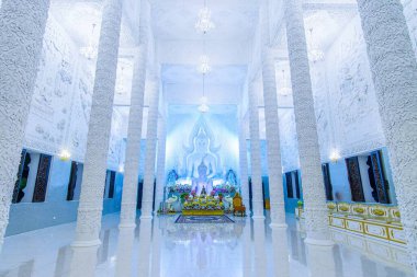 CHIANG, RAI, THAILAND - 10 Mayıs 2019: 10 Mayıs 'ta Chiang Rai' de Wat Huai Pla Kang 'daki koro salonunun iç mimarisi sıva oymaları, dingin Buda heykelleri ve yumuşak ortam ışıklarıyla süslendi.