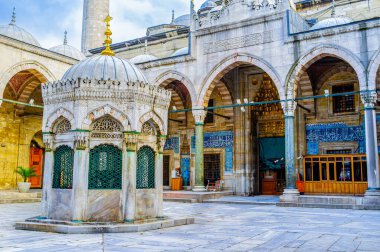 Yeni Camii avlusunun ortasında, İstanbul, Türkiye 'de kubbeli portolar ve mermer kaldırımlarla çevrili abdest çeşmesi