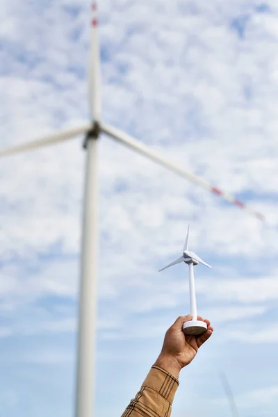 Hand Unrecognizable Person Holding Plastic Windmill Real Wind Turbine Background — Stock Photo, Image