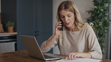 Beyaz bir kadın mali sıkıntılar yaşıyor ve telefon görüşmesi yapıyor. 8K 'da kırmızı helyum kamerayla çekildi..  