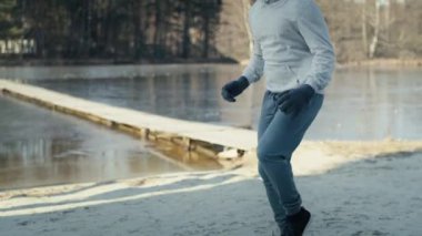 Yetişkin beyaz bir adam kış yüzmesinden önce ısınmak için sohbet ediyor. 8K 'da kırmızı helyum kamerayla çekildi..