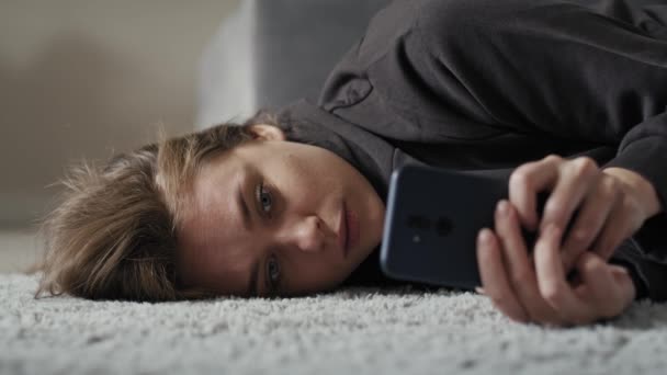 Biała Smutna Kobieta Używająca Telefonu Komórkowego Leżąca Dywanie Nakręcony Aparatem — Wideo stockowe