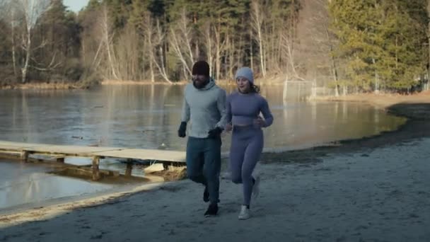 冬の水泳の前に暖かくなるために大人の白人カップルジョギング 8Kでレッドヘリウムカメラで撮影 — ストック動画