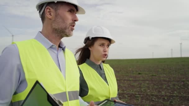 Deux Ingénieurs Caucasiens Marchant Sur Champ Des Éoliennes Discutant Tourné — Video