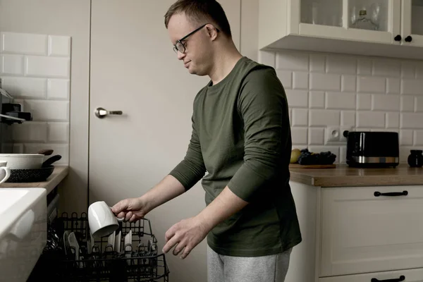Erwachsener Mann Mit Syndrom Lädt Geschirrspüler Allein Hause — Stockfoto